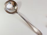 a silver spoon with a mirror on it on a table