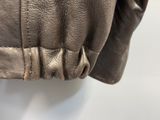 the back of a brown leather jacket hanging on a white wall
