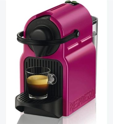 une machine Neso rose avec une tasse de café