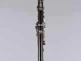 a black and white clarinet on a stand on a gray background