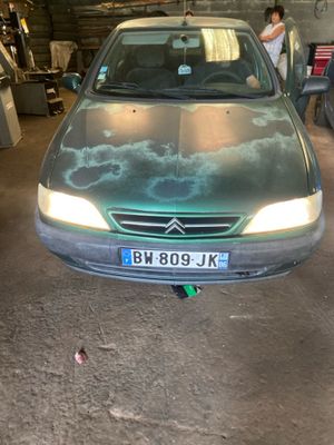 une voiture garée dans un garage où il y a plein de choses par terre