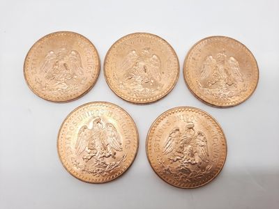 quatre types différents de pièces d'or reposant sur une surface blanche