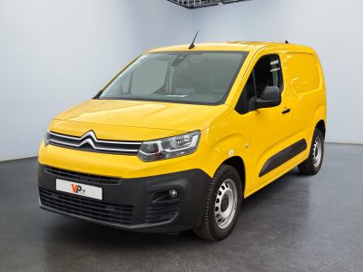 La camionnette jaune est garée dans une pièce blanche au sol noir