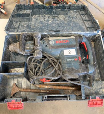 une boîte à outils contenant des outils, posée sur le sol