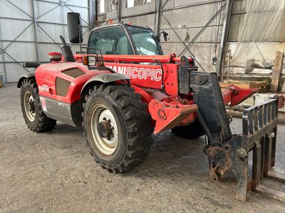 un tracteur rouge garé à l'intérieur d'un bâtiment