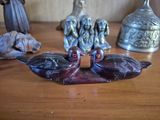 several figurines of birds are sitting on a wooden table