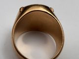 an image of a gold ring on a white surface