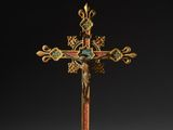 une croix dorée surmontée d'un oiseau, sur fond noir