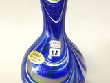 un vase en verre bleu sur lequel est accrochée une étiquette jaune