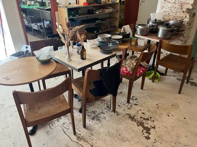 a table and chairs in a room with a lot of clutter on the floor