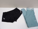 deux paires de shorts Nike et un legging posés sur une table