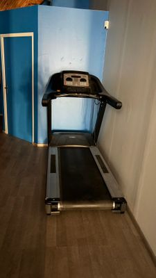 a treadmill in the corner of a room with a blue wall