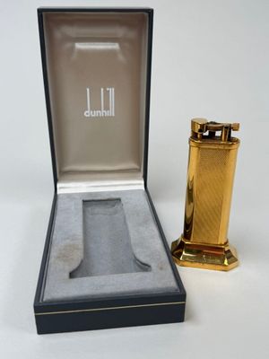 a gold lighter in a black box next to a gold lighter