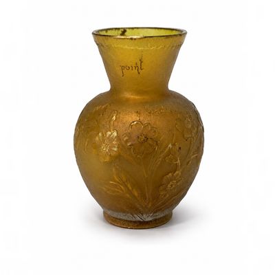 un vase en or posé sur une surface blanche