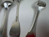 three spoons and a fork on a white table