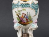 a white vase with a painting on it sitting on a table