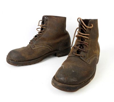 une paire de bottes en cuir marron à lacets sur fond blanc