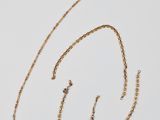 un ensemble composé d'un collier et de boucles d'oreilles en or sur fond blanc