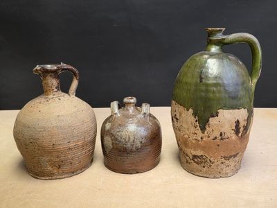 three vases sitting on a table with a black background