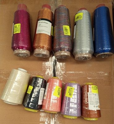 de nombreuses bobines de fil de différentes couleurs dans une boîte