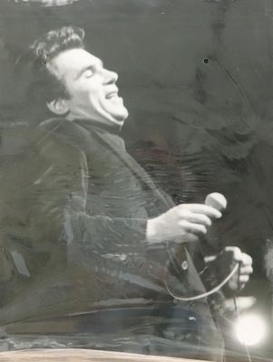 une photo en noir et blanc d'un homme chantant dans un micro