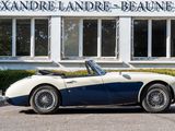 a blue and white sports car parked in front of a building