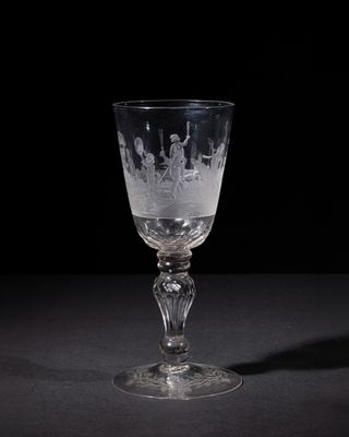 a wine glass with a pattern on it sitting on a table