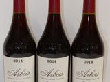 trois bouteilles de vin sont alignées sur une table