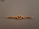 une image représentant une broche en or ornée de fleurs