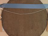 a picture of a wooden object with a blue ribbon around it