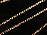 a close up of a gold chain on a black surface