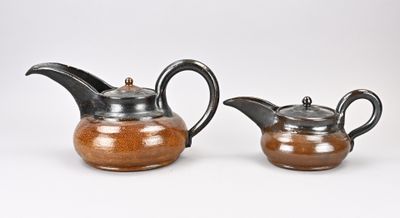 une paire de théières en céramique marron et noire sur fond blanc