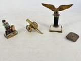 plusieurs figurines représentant un homme assis sur une chaise à côté d'un canon
