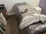 un lit sur lequel sont posés une couverture et une télécommande