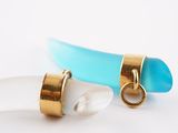 two pieces of glass and gold are sitting on a white surface