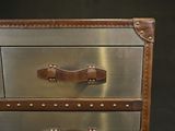 a close up of a metal and leather chest of drawers