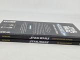 two star wars books are stacked on top of each other