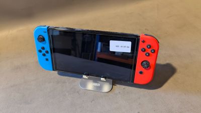 une manette de jeu Nintendo Wii rouge et bleue posée sur un support