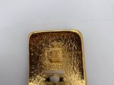 a close up of a piece of gold on a white surface