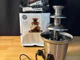 the chocolate fountain is sitting on a wooden table next to a bag of chocolate