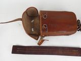 a brown bag with a leather handle and a ruler next to it