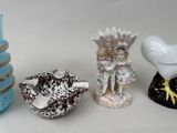 three vases and a bird on a white table