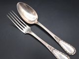 two spoons and a fork on a black surface