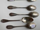 four spoons are lined up in a row on a table