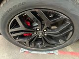the tire of a black car with red brake pads on it