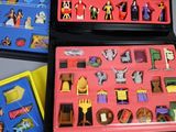 three plastic toys in a plastic case on a table