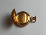 an image of a gold pocket watch on a white surface