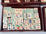 two wooden boxes filled with wooden dominos and wooden pegs