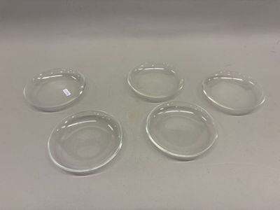 quatre bols en verre transparent posés sur une table blanche