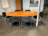 tables and chairs in a room with a whiteboard on the wall
